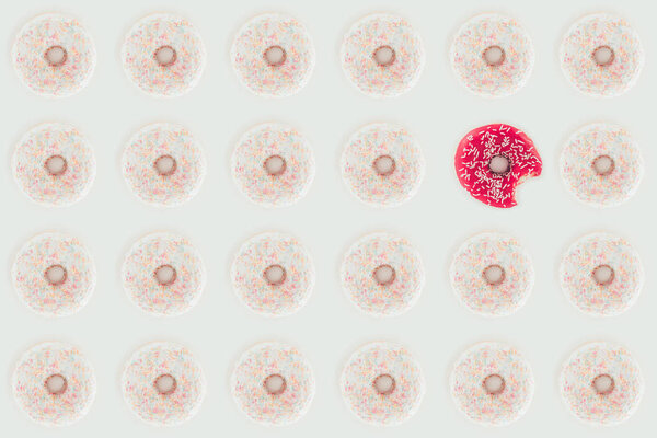 top view of seamless pattern with white and pink doughnuts isolated on white