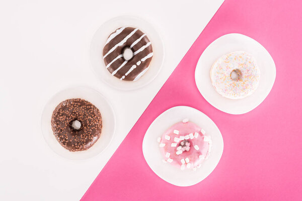top view of various tasty doughnuts on plates