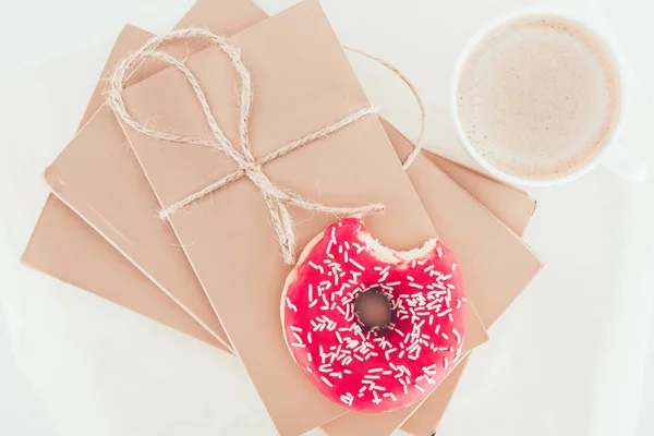 top view of doughnut on wrapper packages with cup of coffee