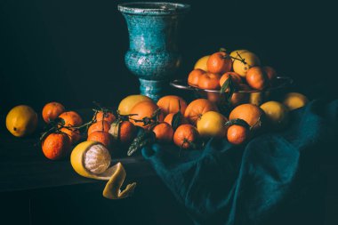taze limon ve mandalina süzgeç içinde oluşan görünümü karanlık masa örtüsü ile tabloda kadar kapatın