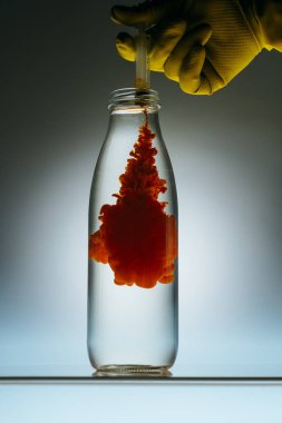 şişe su ile içine şırıngadan kişi yağan kırmızı boya görünümünü kırpılmış