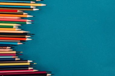 Top view of composition of colorful pencils isolated on blue background clipart