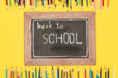 Top view of Back to school inscription on chalk board with pencils clipart