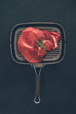 herb ile çiğ biftek ızgara tava üzerinde yukarıdan