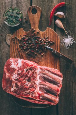 top view of raw pork ribs and spices on wooden cutting board clipart