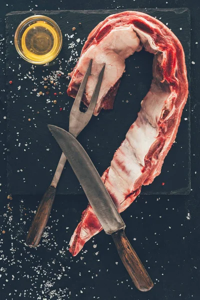 Top view of raw pork ribs slice with cutlery and oil on stone slate — Stock Image Top View Raw Pork Ribs Slice Cutlery Oil Stone Slate Stock Image