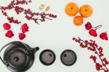 top view of chinese new year composition with tea and branches of berries isolated on white clipart