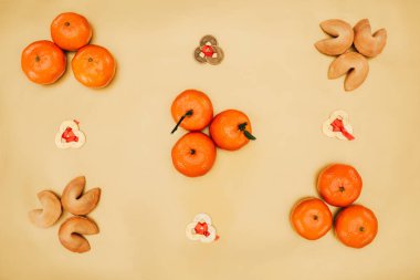 top view of chinese coins with tangerines and fortune cookies composition for new year clipart