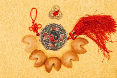 top view of chinese talisman surrounded with fortune cookies on golden surface, Chinese New Year concept clipart