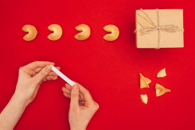 kadın el yapımı giftbox, Çin yeni yılı kavramı ile kırmızı yüzey üzerinde şans kurabiyesi açılış resmini kırpılmış