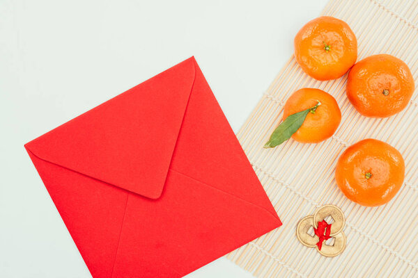 top view of red envelope with tangerines and chinese coins talisman, Chinese New Year concept