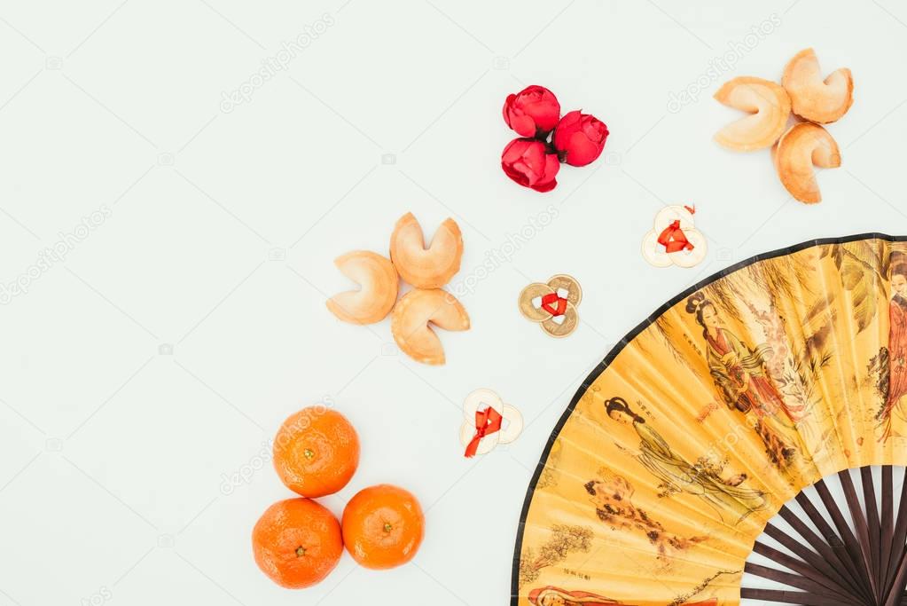 top view of chinese new year composition with handheld fan isolated on white
