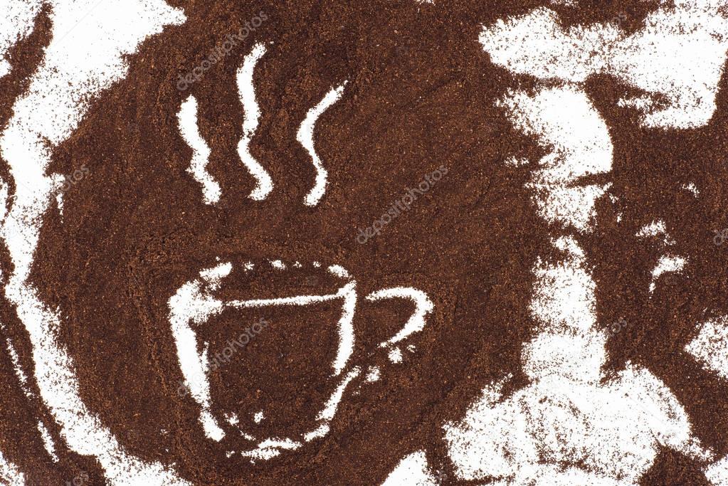 top view of cup of coffee sign drawn in coffee on white