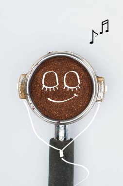 top view of coffee tamper with smiley face and earphones isolated on white clipart