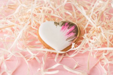 close up view of sweet heart shaped cookie and decorative straw on pink, st valentines holiday concept clipart