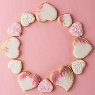 düz lay pembe yüzeyinde izole sırlı kalp şeklinde kurabiye düzenlenmesi ile