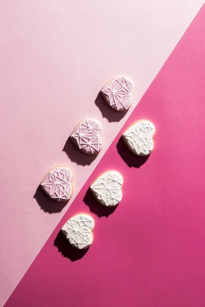 Vista Superior Biscoitos Forma Coração Envidraçado Dispostos Superfície Rosa — Fotografia de Stock