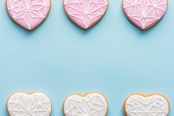 flat lay with arranged glazed heart shaped cookies isolated on blue, st valentines day holiday concept