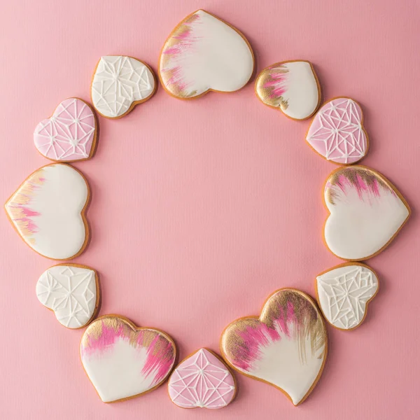 ピンクの面に分離された艶をかけられたハート形のクッキーの配置と平面レイアウト — ストック写真