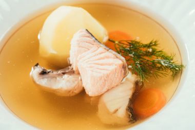 patates, havuç ve beyaz tabak içinde servis otlar ile somon çorbası yakın çekim 