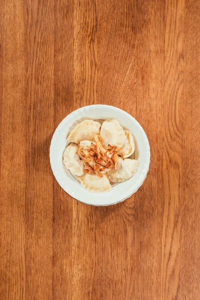Dumplings Fried Onions Top Laying Plate Wooden Surface — Free Stock Photo