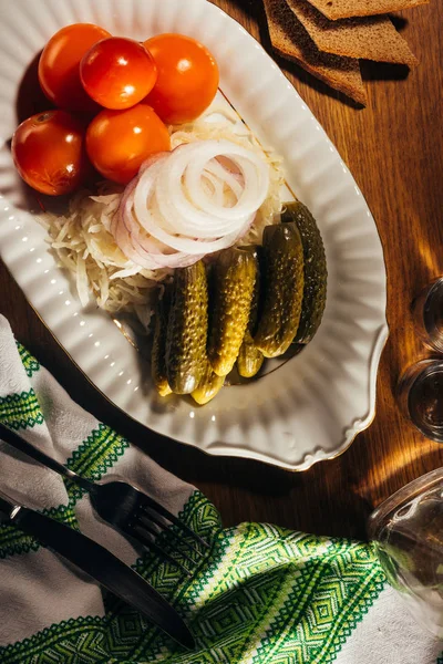Top view of sauerkraut served with pickled vegetables on white plate on wooden table with napkin — Stock Image Top View Sauerkraut Served Pickled Vegetables White Plate Wooden Table Stock Photo