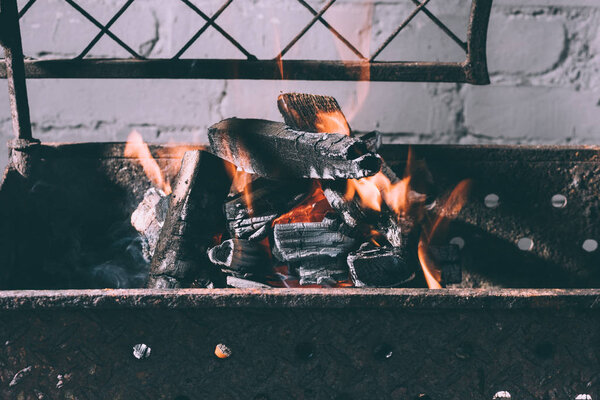 close-up view of grill with fire, flames and charcoals indoors