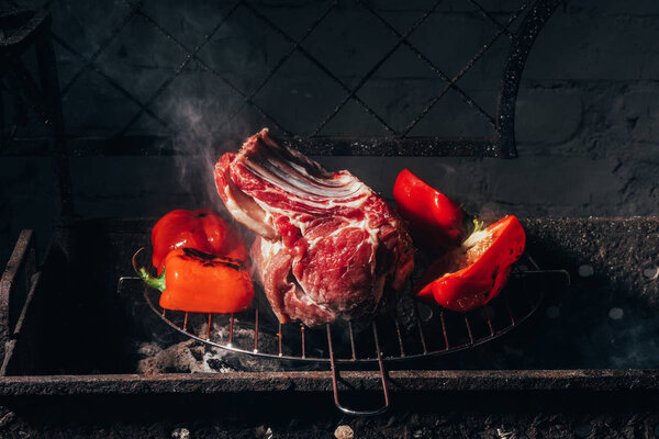 close-up view of delicious raw meat with ribs and peppers preparing on grill