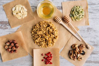 top view of homemade granola ingredients on baking parchment pieces clipart