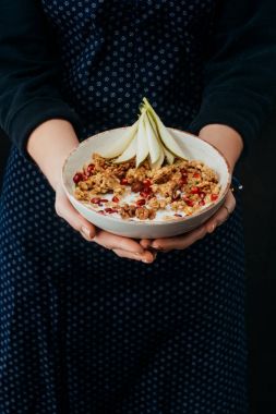 kadın aşçı ev yapımı granola bir kase tutarak kırpılmış görüntü 