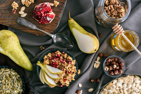 вид сверху на ингредиенты мюсли и миску с мюсли на столе
