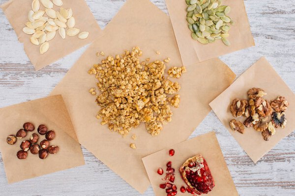 top view of crunchy granola ingredients on baking parchment pieces