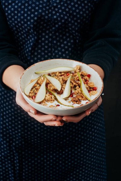 cropped image of woman holding bowl with homemade granola