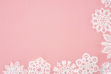 Noel arka plan kopya alanı ile pembe üzerinde kağıt kar taneleri ile