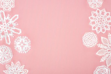 Pembe üzerinde kağıt kar taneleri ile Noel arka plan