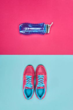 Sports equipment with shoes and water bottle isolated on pink and blue clipart