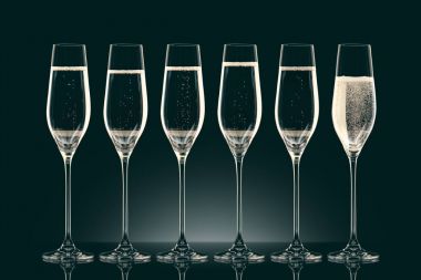 six transparent glasses with champagne on black clipart