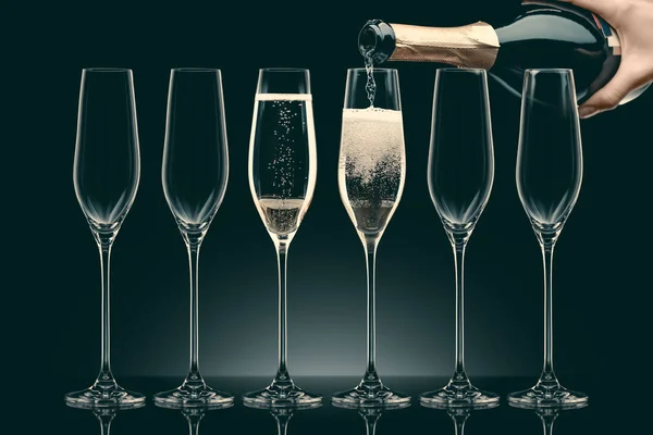 Cropped Image Woman Pouring Champagne Bottle Six Transparent Glasses Black — Stock Photo, Image