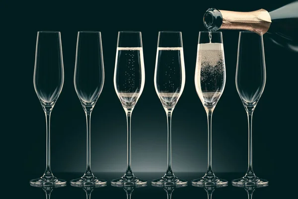 Versando Champagne Dalla Bottiglia Sei Bicchieri Trasparenti Sul Nero — Foto Stock