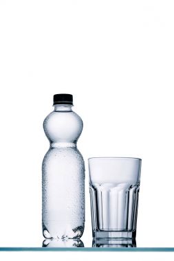 tam plastik şişe su ve boş bardak beyaz izole