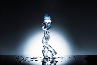 crumpled plastic bottle of water on dark  clipart