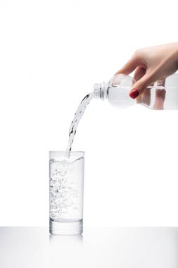 Kadın temiz su dökerek kırpılmış atış cam plastik şişe üzerinde beyaz izole içine