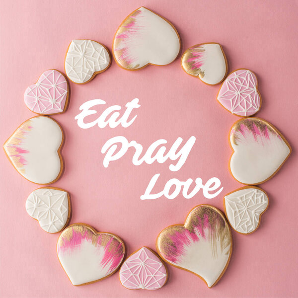 flat lay with arrangement of glazed heart shaped cookies isolated on pink surface