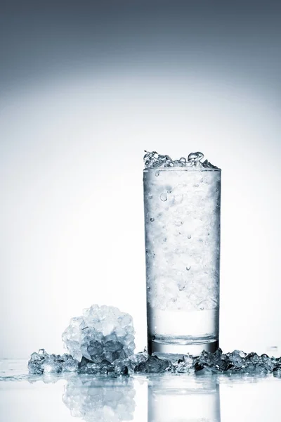 Vaso Agua Fría Con Hielo Sobre Superficie Reflectante Sobre Blanco — Foto de Stock