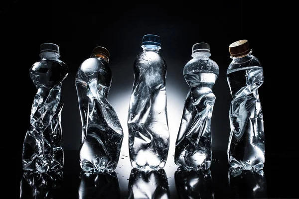 Διάφορα Τσαλακωμένο Πλαστικά Μπουκάλια Του Νερού Στην Γραμμή Σκούρο — Φωτογραφία Αρχείου