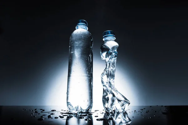 Ανέγγιχτη Και Τσαλακωμένο Μπουκάλια Νερού Στο Σκοτάδι — Φωτογραφία Αρχείου