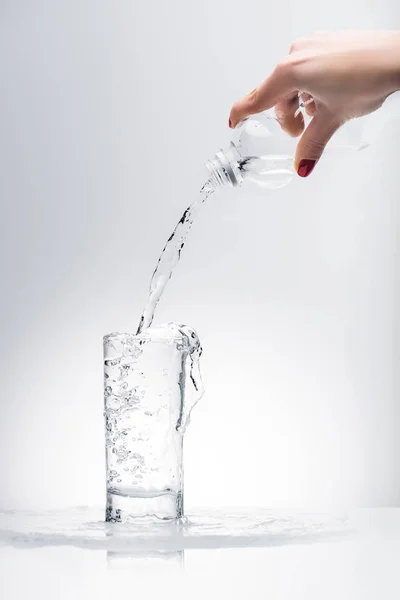 用塑料瓶将淡水倒入玻璃杯中的女人 — 图库照片