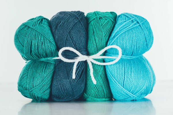 blue and green knitting yarn balls on white