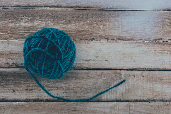 top view of blue knitting yarn ball on wooden background