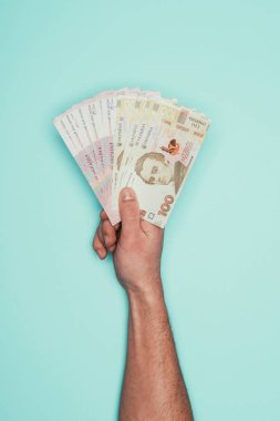 Ukraynalı para üzerinde turkuaz izole tutan adamın kırpılmış atış